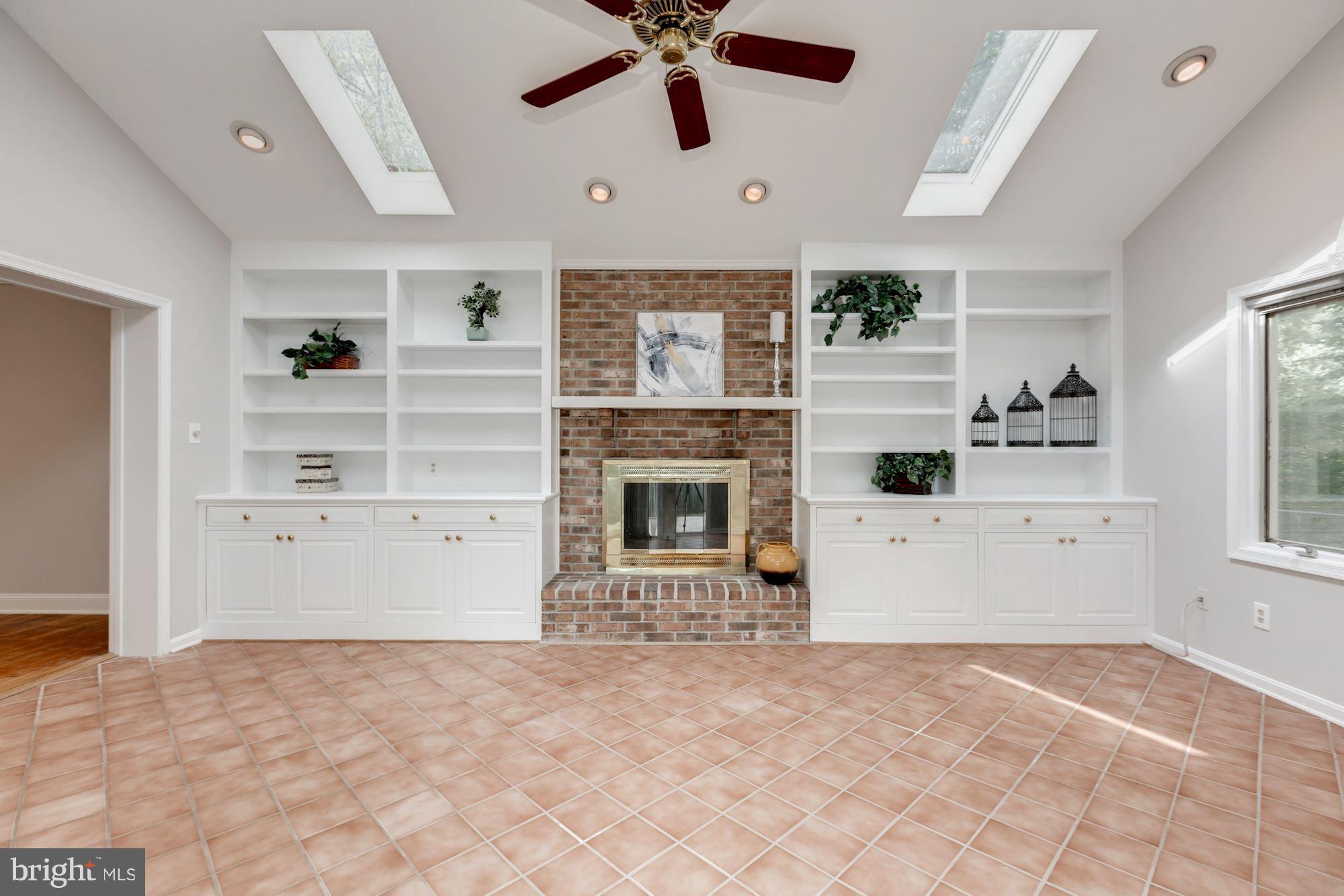 8425 Thames Street Springfield, VA 22151 - Photo 11 of 30 a view of a livingroom with a fireplace a ceiling fan and windows