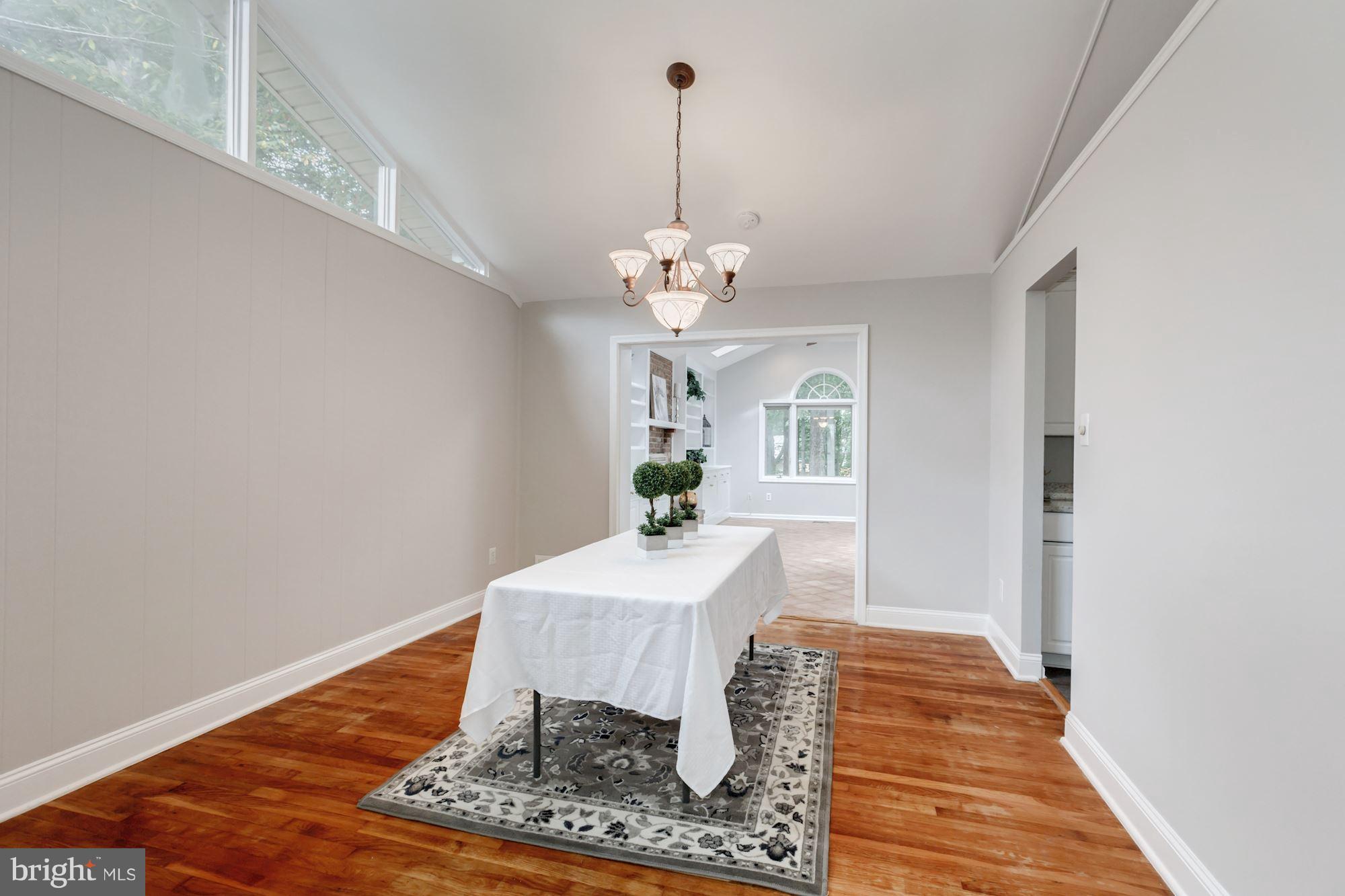 8425 Thames Street Springfield, VA 22151 - Photo 7 of 30 a dining room with wooden floor a chandelier a rug and a chandelier