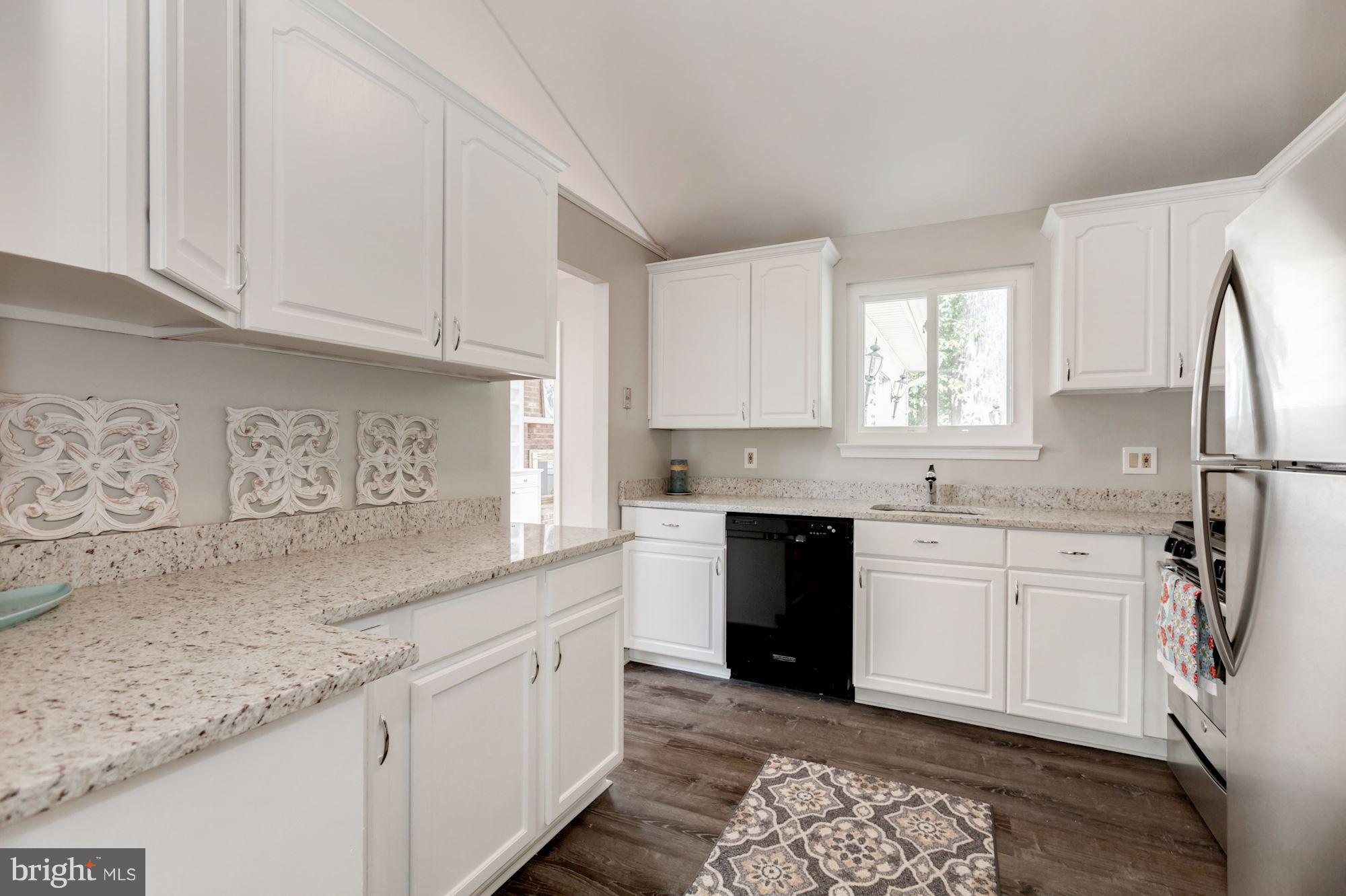8425 Thames Street Springfield, VA 22151 - Photo 9 of 30 a kitchen with granite countertop white cabinets and white appliances
