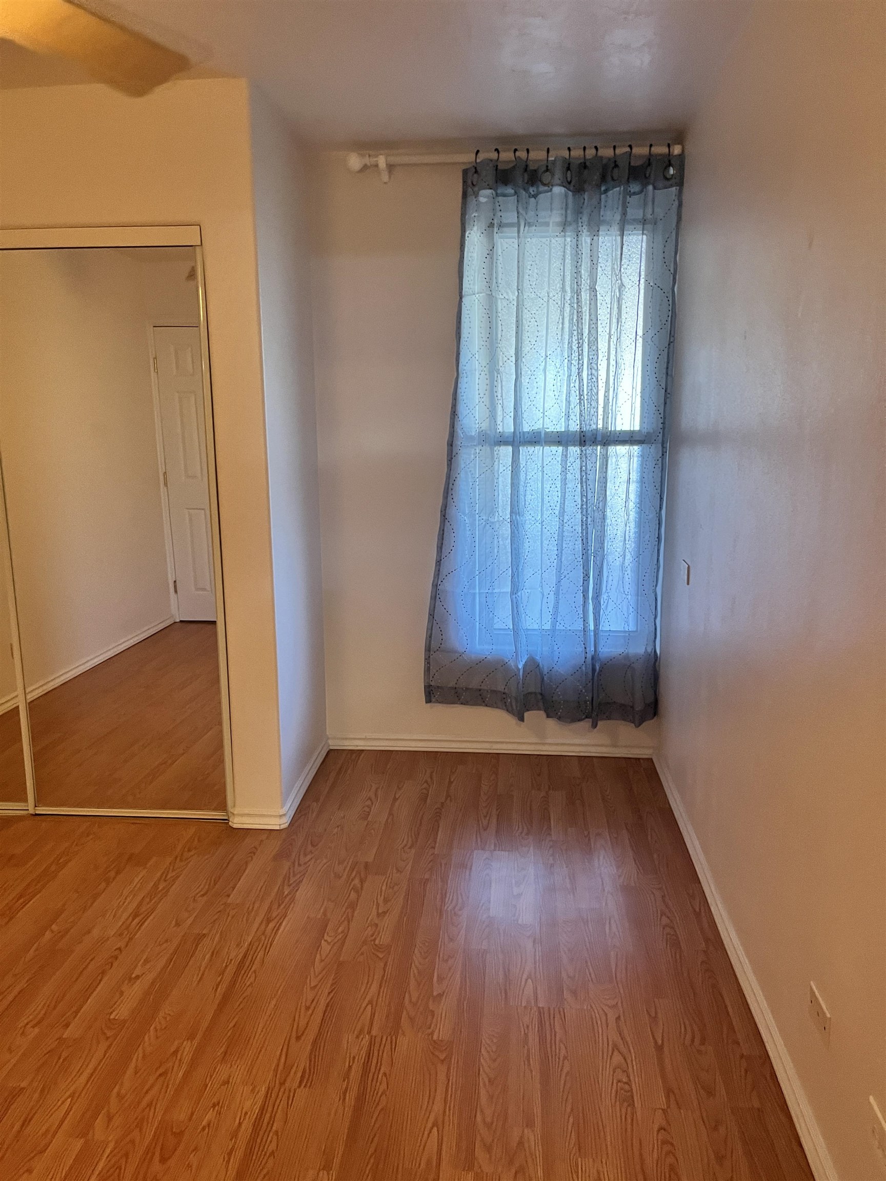 495 Liholiho Street, Unit 204 Wailuku, HI 96793 - Photo 31 of 42 an empty room with wooden floor and windows