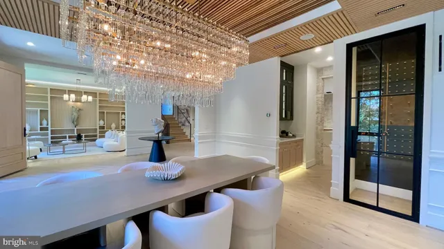 a view of a hallway with wooden cabinets and a refrigerator