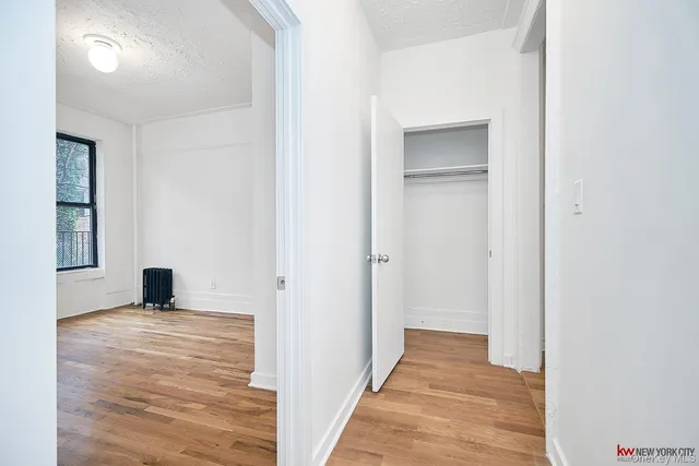a view of a room with wooden floor and a bathroom