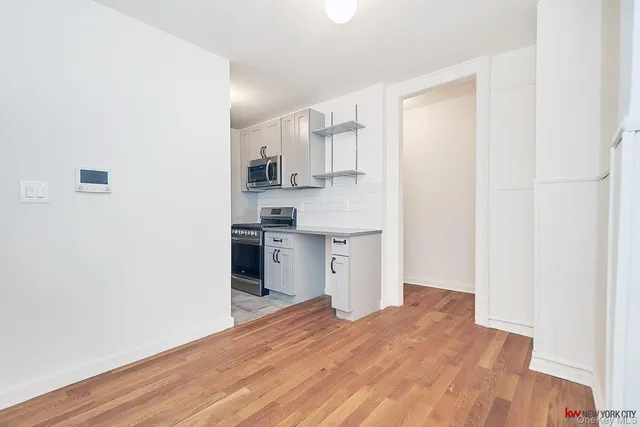 a view of a kitchen with wooden floor and a sink