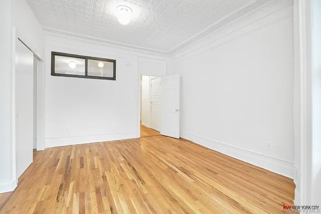 a view of empty room with wooden floor