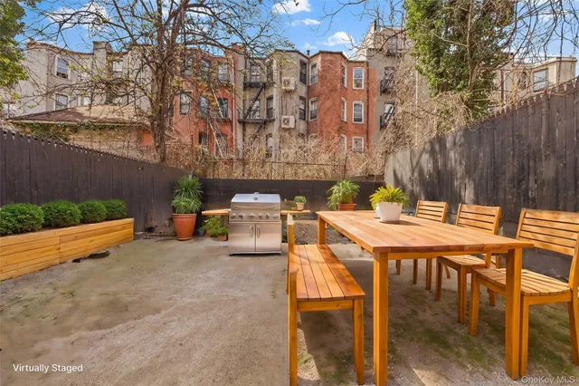 a view of a patio with table and chairs with wooden fence