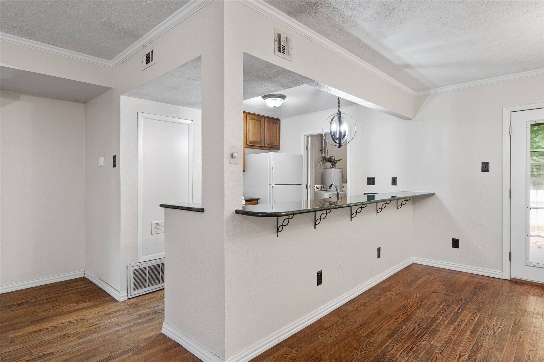 806 Castle Ridge Road, Unit C Austin, TX 78746 - Photo 8 of 28 An inviting open-concept layout connects the kitchen to a spacious living area, highlighted by rich hardwood flooring.