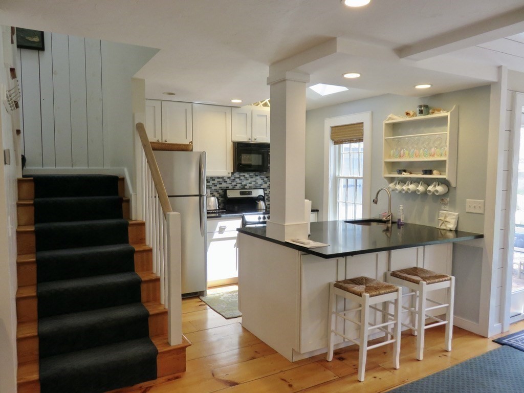 40 Brant Rock Road, Unit 40 Mashpee, MA 02649 - Photo 11 of 16 a kitchen with sink cabinets and refrigerator