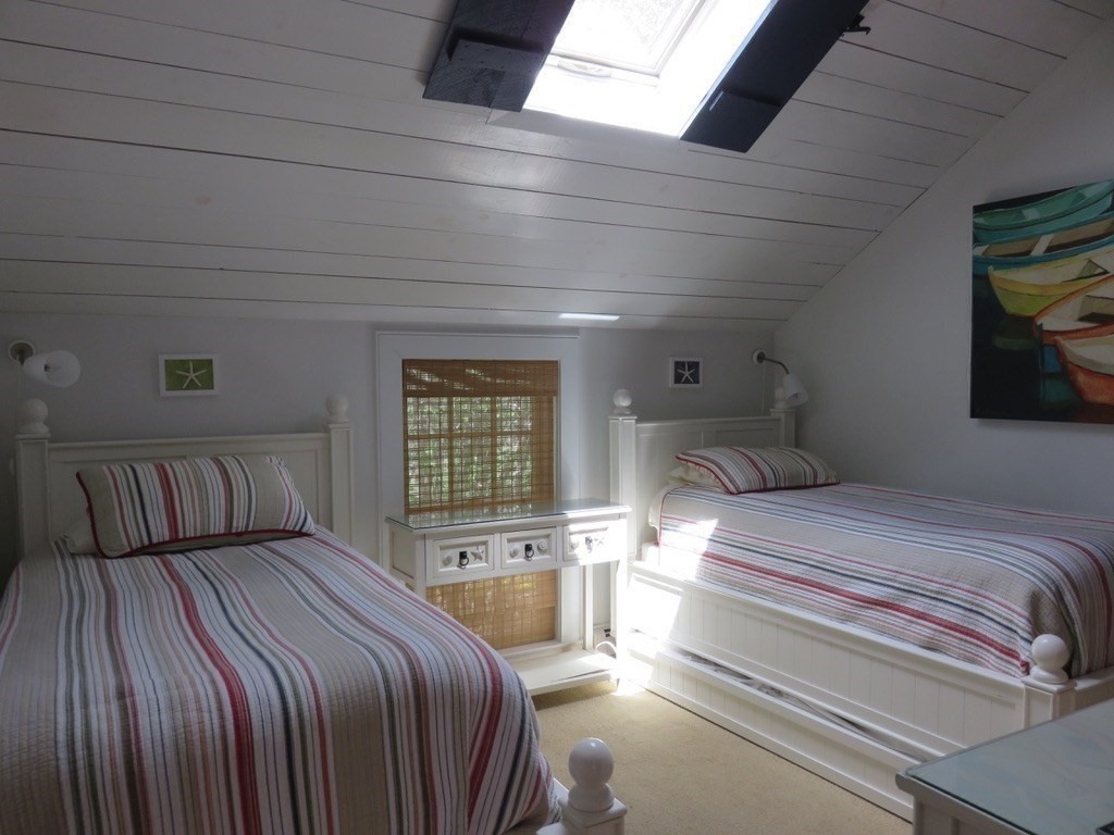 40 Brant Rock Road, Unit 40 Mashpee, MA 02649 - Photo 9 of 16 a bedroom with a large bed and a chandelier