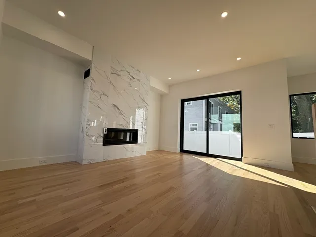 an empty room with wooden floor and fireplace