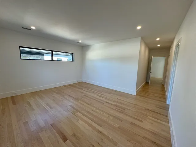 a view of empty room with wooden floor