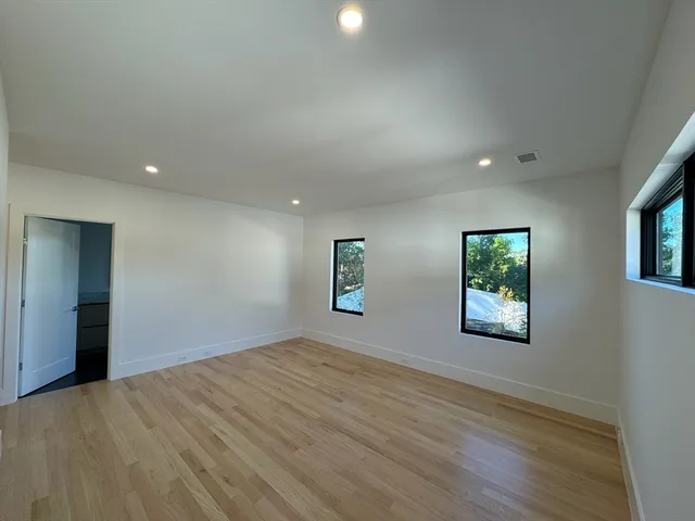 an empty room with windows and closet