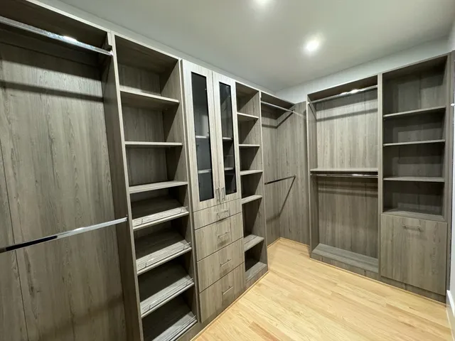a view of walk in closet with empty racks