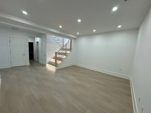 an empty room with wooden floor and white walls