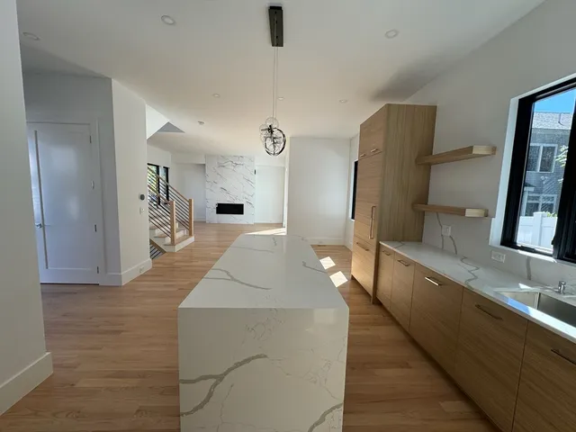 a large white kitchen with kitchen island a sink stainless steel appliances and cabinets