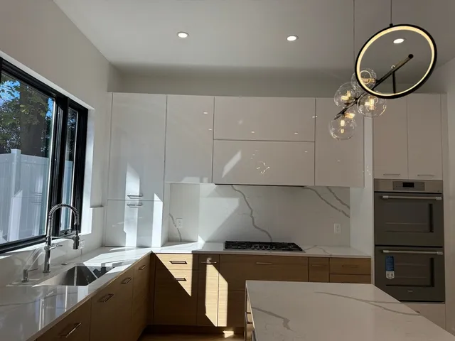 a kitchen with stainless steel appliances granite countertop a sink a stove and a refrigerator