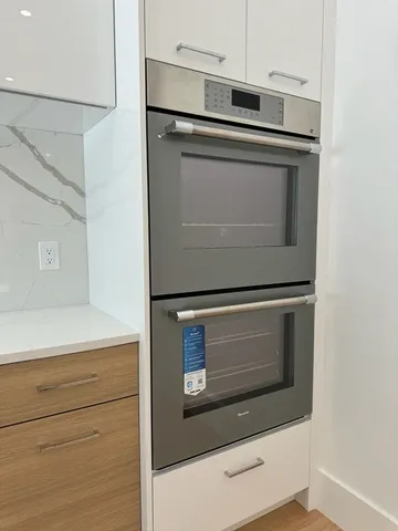a stove top oven sitting inside of a kitchen