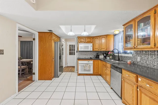 a large kitchen with stainless steel appliances granite countertop a refrigerator and a sink