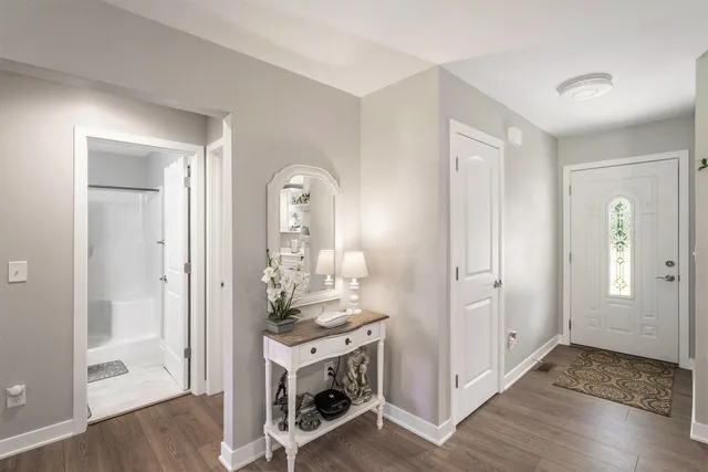 a view of a livingroom with kitchen and front door