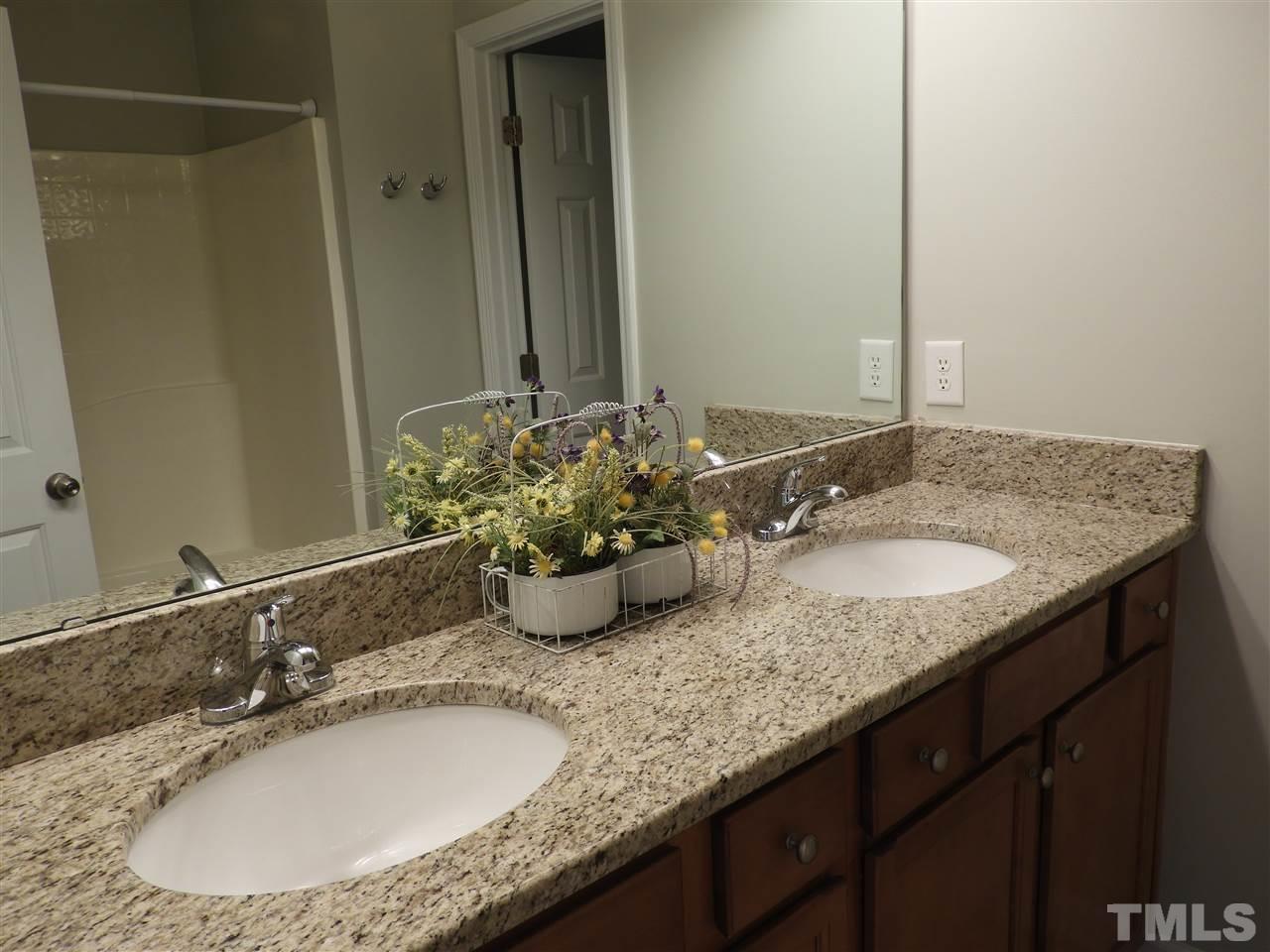 7245 Racine Way Raleigh, NC 27690 - Photo 20 of 29 a bathroom with a granite countertop sink and a mirror