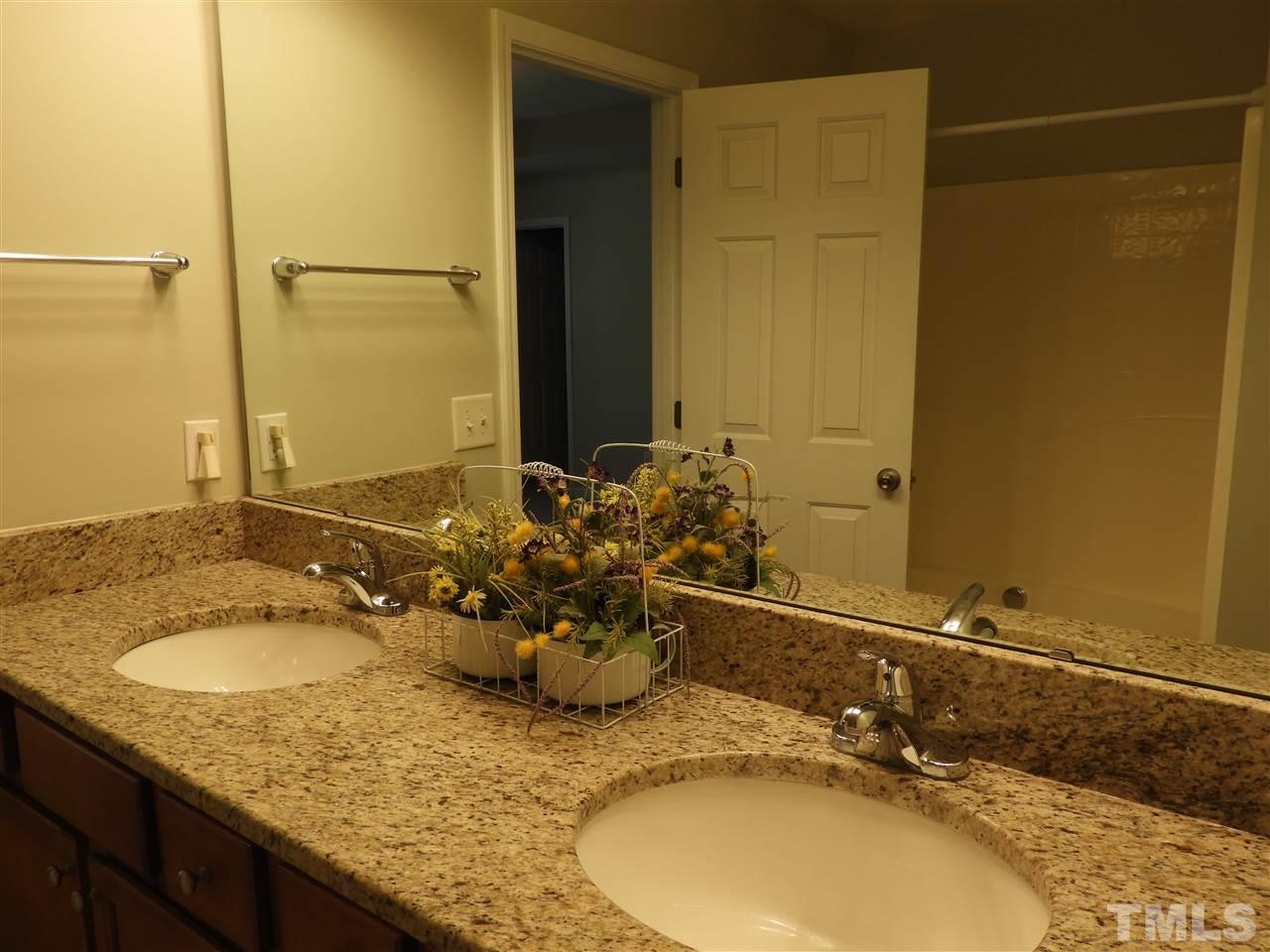 7245 Racine Way Raleigh, NC 27690 - Photo 21 of 29 a bathroom with a granite countertop sink and a mirror