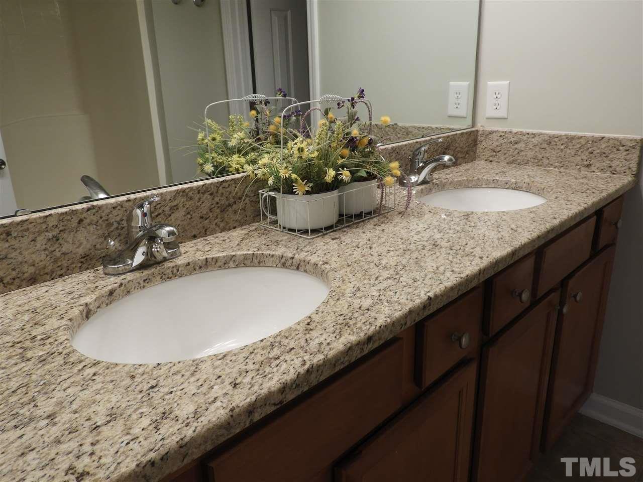7245 Racine Way Raleigh, NC 27690 - Photo 23 of 29 a bathroom with a granite countertop sink a mirror and vanity