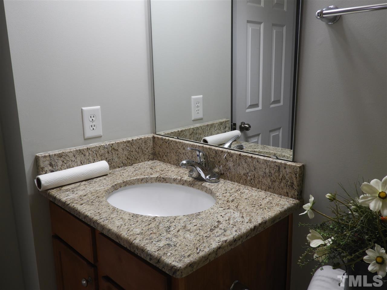 7245 Racine Way Raleigh, NC 27690 - Photo 26 of 29 a bathroom with a granite countertop sink and a mirror
