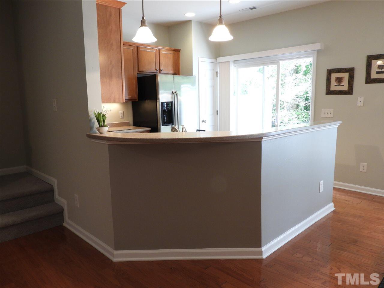 7245 Racine Way Raleigh, NC 27690 - Photo 7 of 29 a kitchen with stainless steel appliances granite countertop a refrigerator a sink dishwasher a stove and white countertops with wooden floor