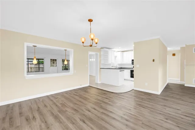 a view of a kitchen with wooden floor and a large window