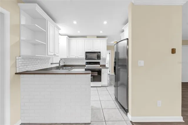 a kitchen with stainless steel appliances granite countertop a refrigerator and a stove