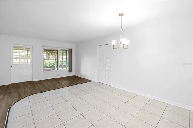 an empty room with kitchen view and windows