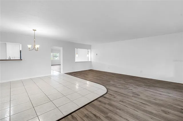 an empty room with wooden floor view and window