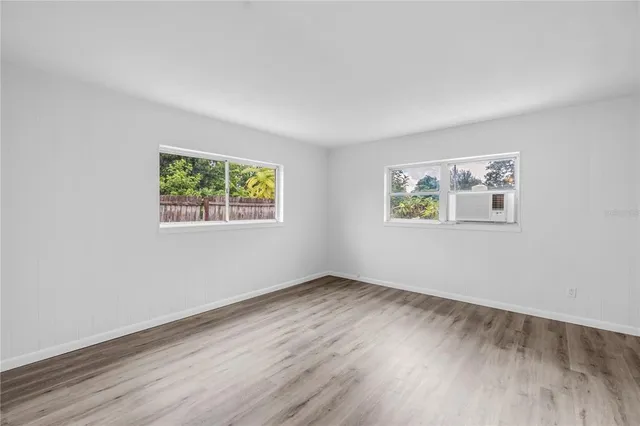 a view of an empty room with wooden floor