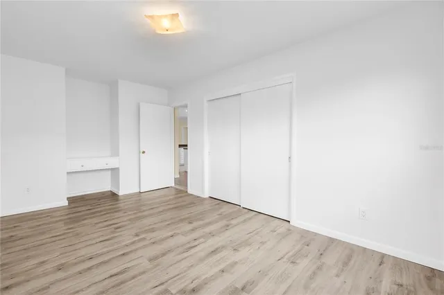 an empty room with wooden floor and window