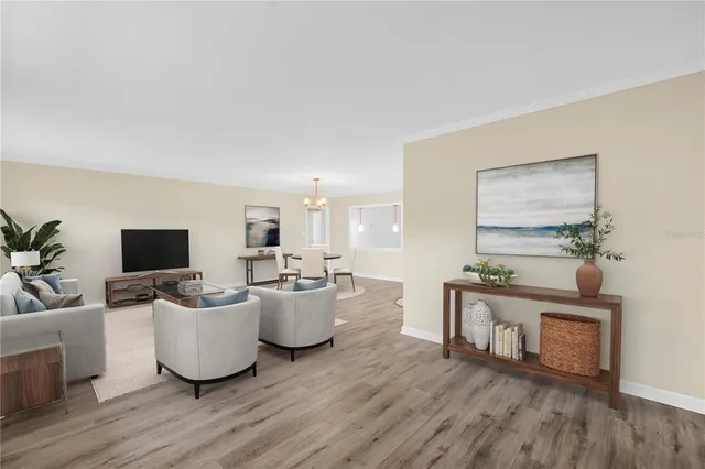 a living room with furniture a flat screen tv and a wooden floor