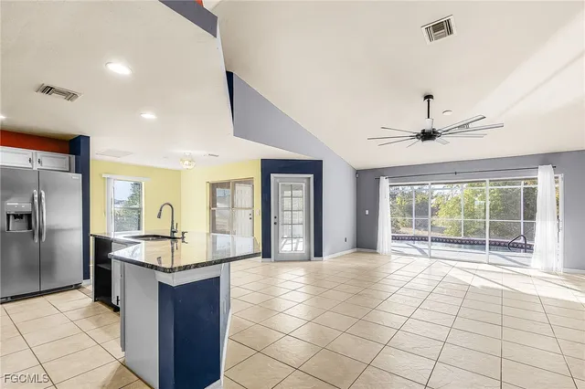 a kitchen with granite countertop a sink and a refrigerator