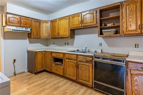 a kitchen with stainless steel appliances granite countertop a stove a sink and a microwave