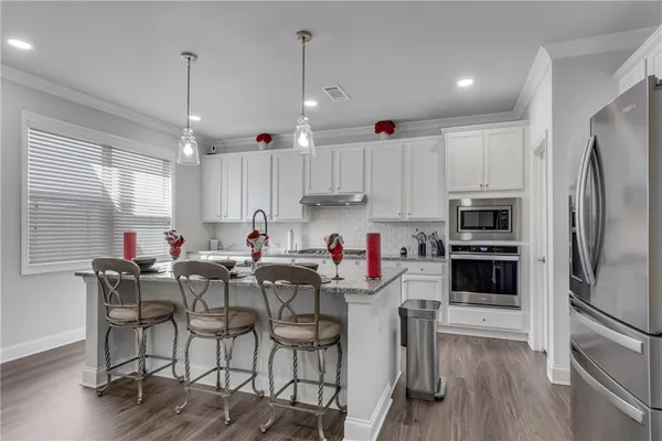 a kitchen with stainless steel appliances granite countertop a sink stove and cabinets