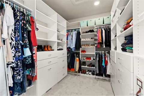 a view of walk in closet with clothes and shoes