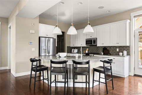 a dining room with furniture a chandelier and wooden floor