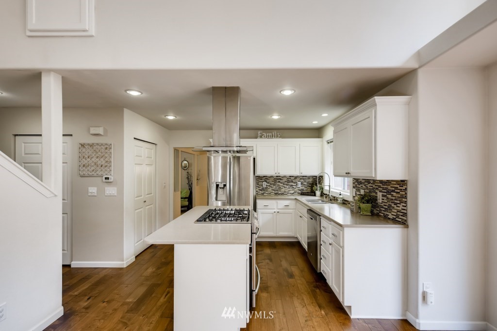 3306 201st Place Southeast Bothell, WA 98012 - Photo 13 of 28 a kitchen with stainless steel appliances kitchen island granite countertop a refrigerator and a stove top oven