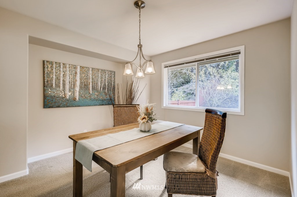 3306 201st Place Southeast Bothell, WA 98012 - Photo 3 of 28 a dining room with furniture a rug and a chandelier