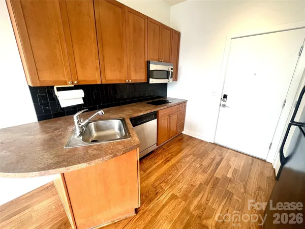 a kitchen with stainless steel appliances wooden cabinets and a sink