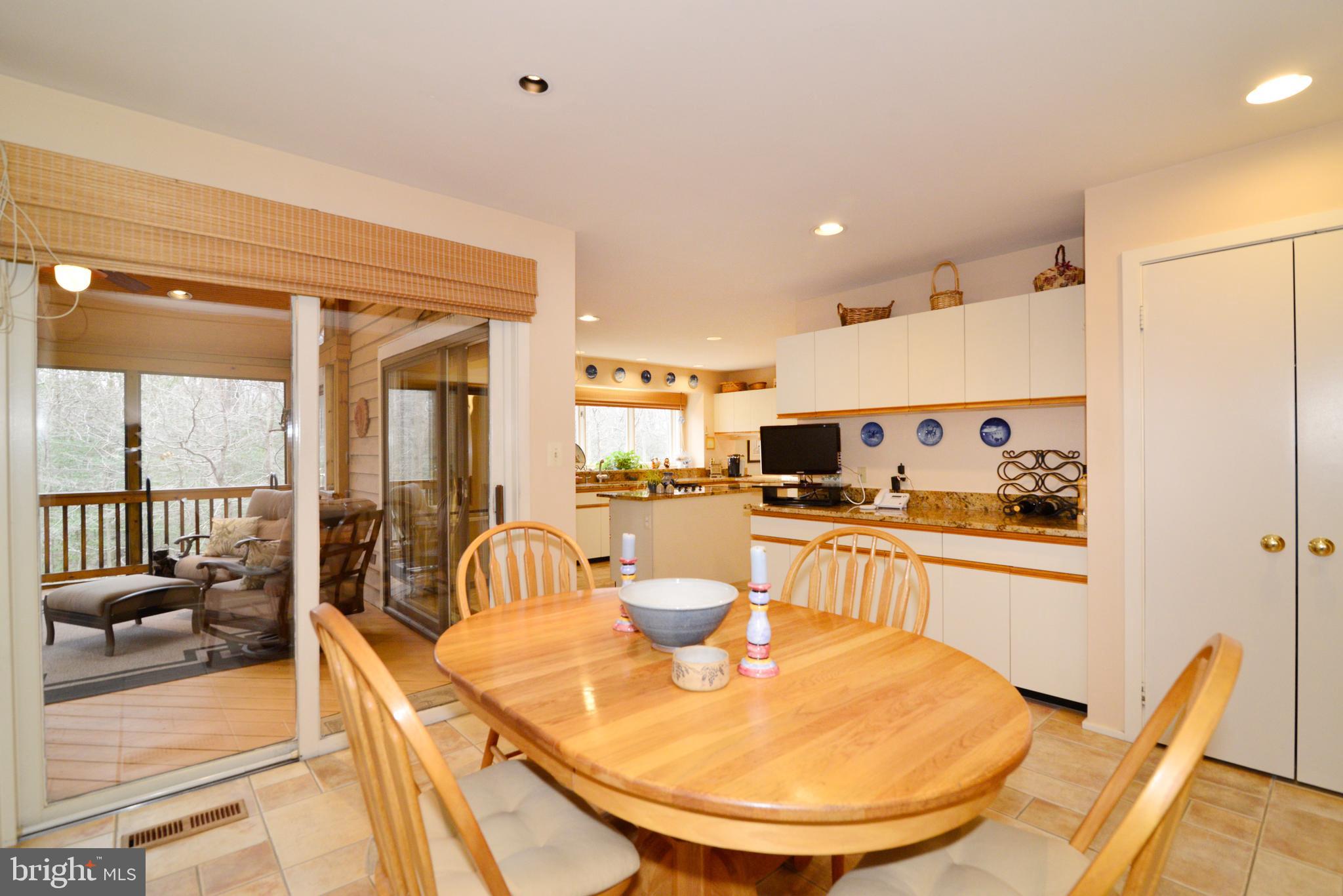 11410 Fieldstone Lane Reston, VA 20191 - Photo 28 of 50 a kitchen with stainless steel appliances granite countertop a stove a sink a refrigerator and a dining table with wooden floor