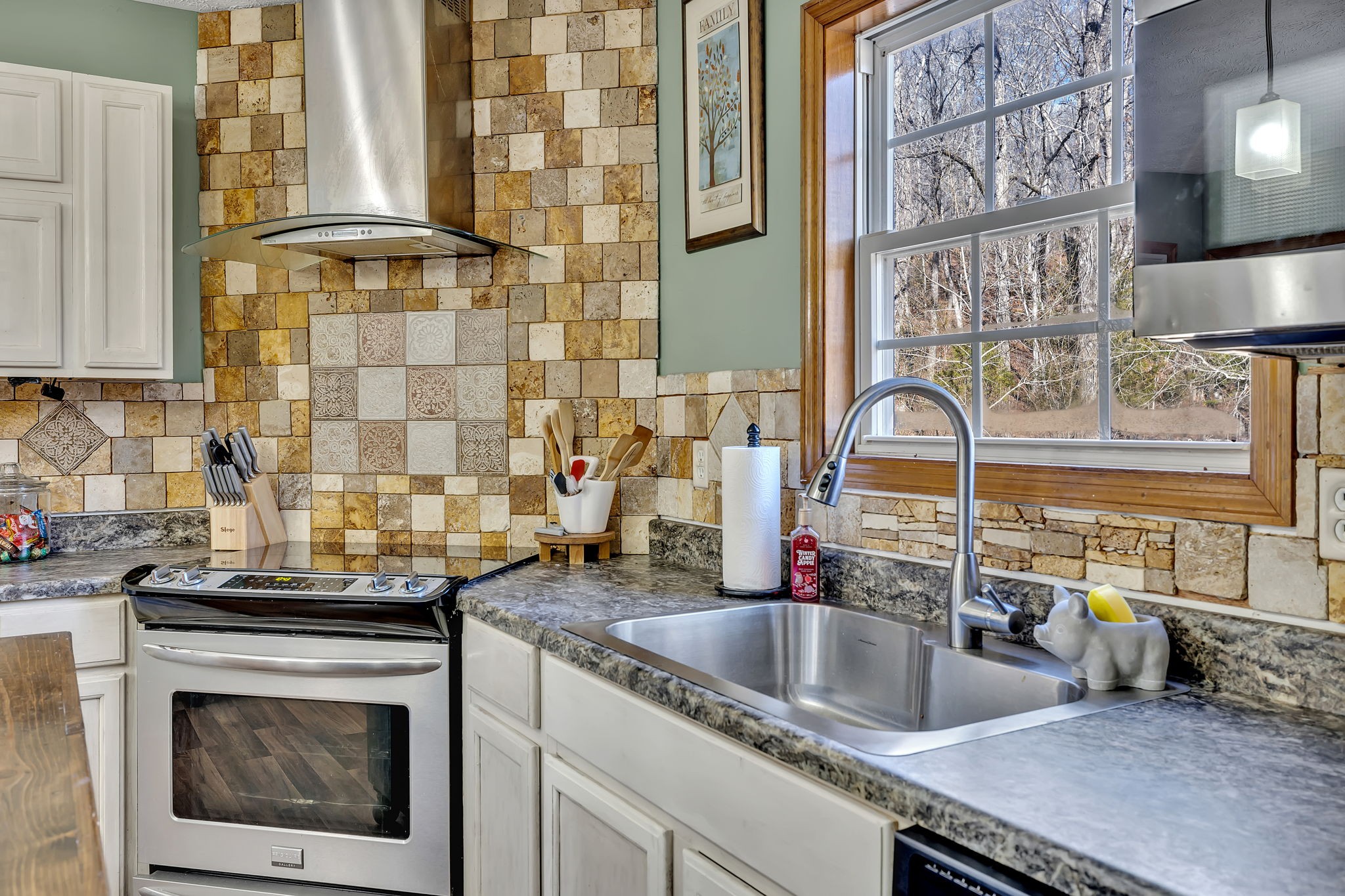 293 Slippery Road Hohenwald, TN 38462 - Photo 19 of 36 a kitchen with a sink and a stove next to a window