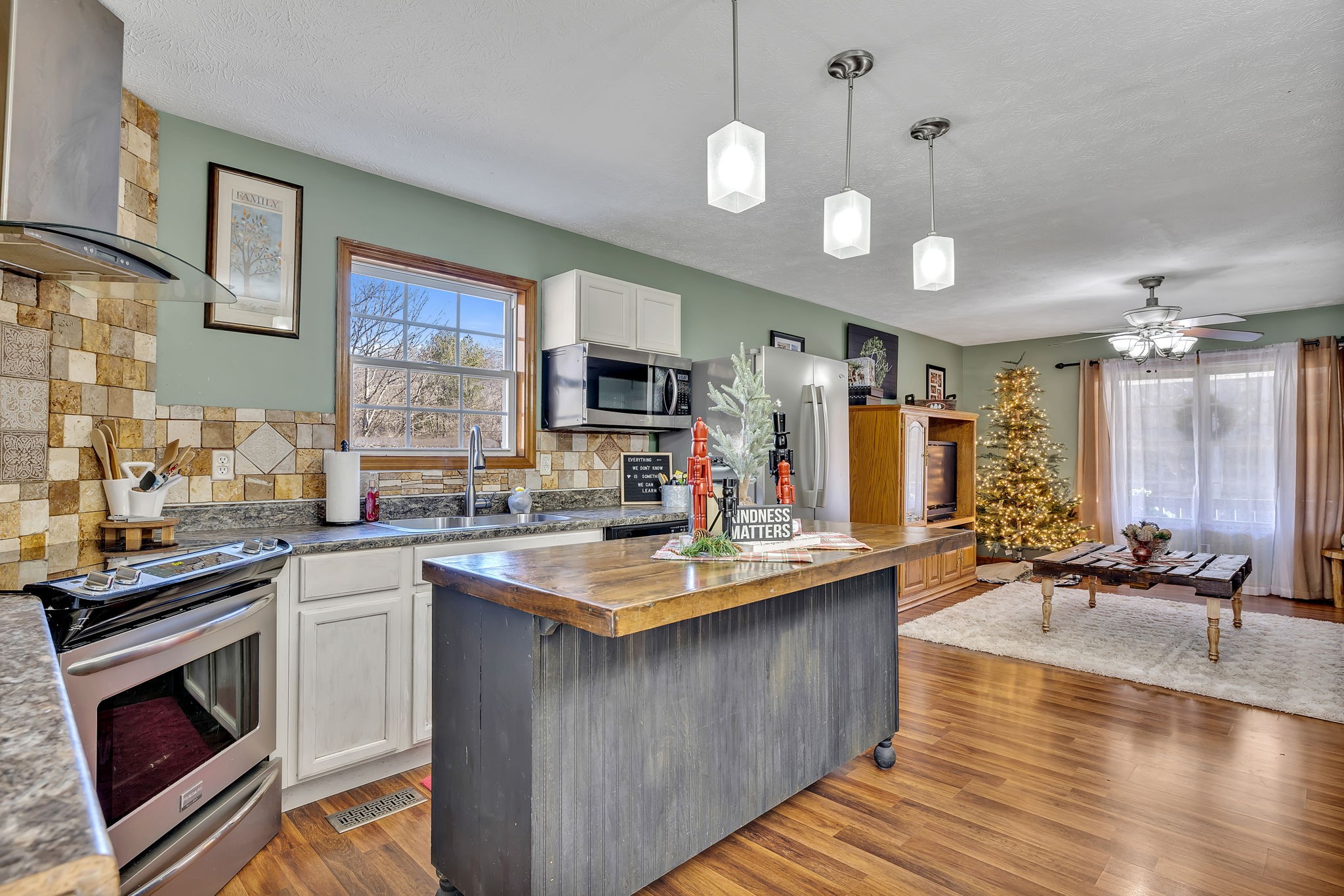 293 Slippery Road Hohenwald, TN 38462 - Photo 21 of 36 a kitchen with stainless steel appliances granite countertop a sink a stove and a wooden floors