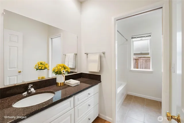 a bathroom with a granite countertop sink and a mirror
