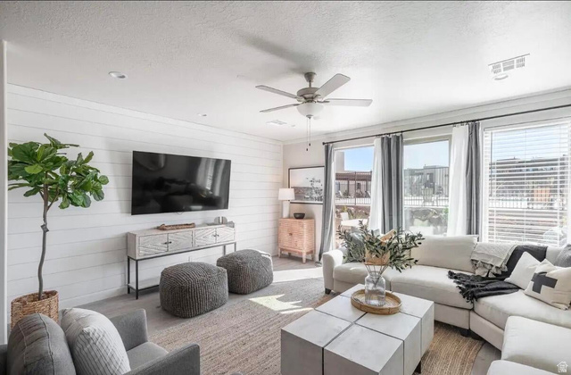 4846 Fishers Is Way St. George, UT 84770 - Photo 11 of 13 Spacious living area featuring a shiplap accent wall, multiple large windows, recessed lighting, and a ceiling fan