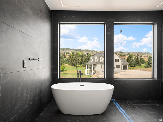 2610 Foxridge Road Garden City, UT 84028 - Photo 56 of 71 2nd Level Master En-Suite, Freestanding soaking tub with a floor-mounted faucet, complemented by large format dark tile walls and flooring