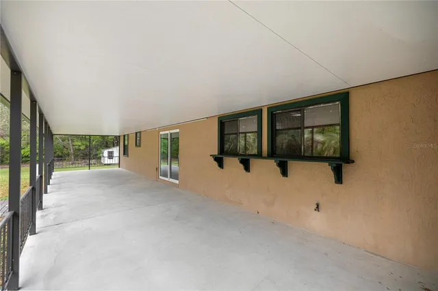 a living room with furniture a flat screen tv and kitchen view