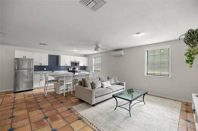 a kitchen with stainless steel appliances granite countertop a stove top oven a sink a dining table and chairs